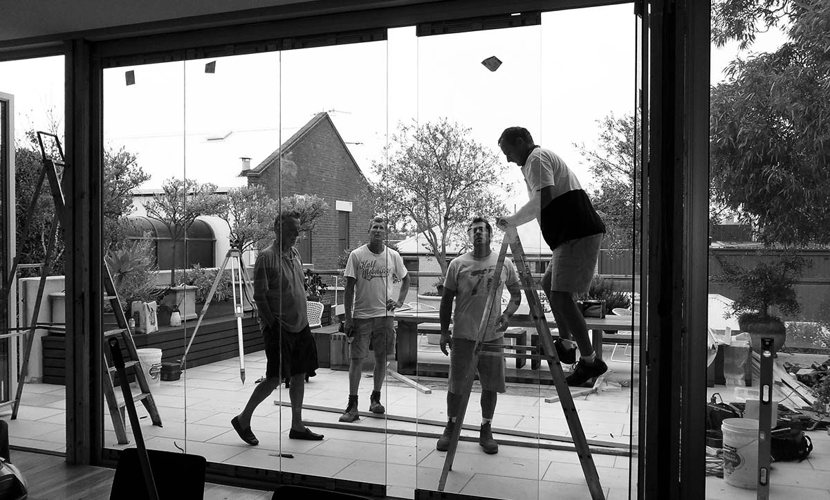 Nuline team installing frameless glass door